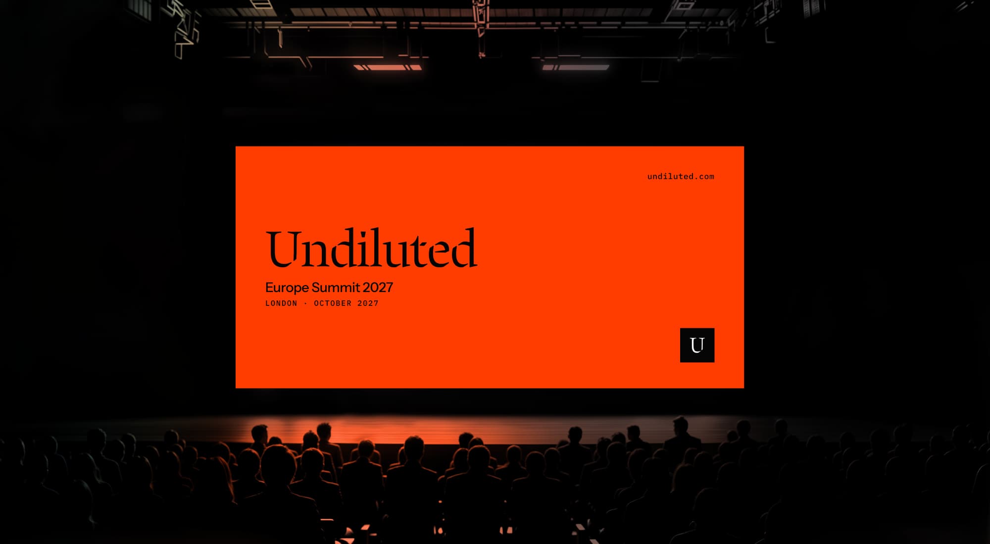 Audience seated in a dark auditorium facing an Undiluted Europe Summit 2027 screen